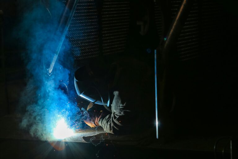 Welder stick welding under a cloud of arc smoke