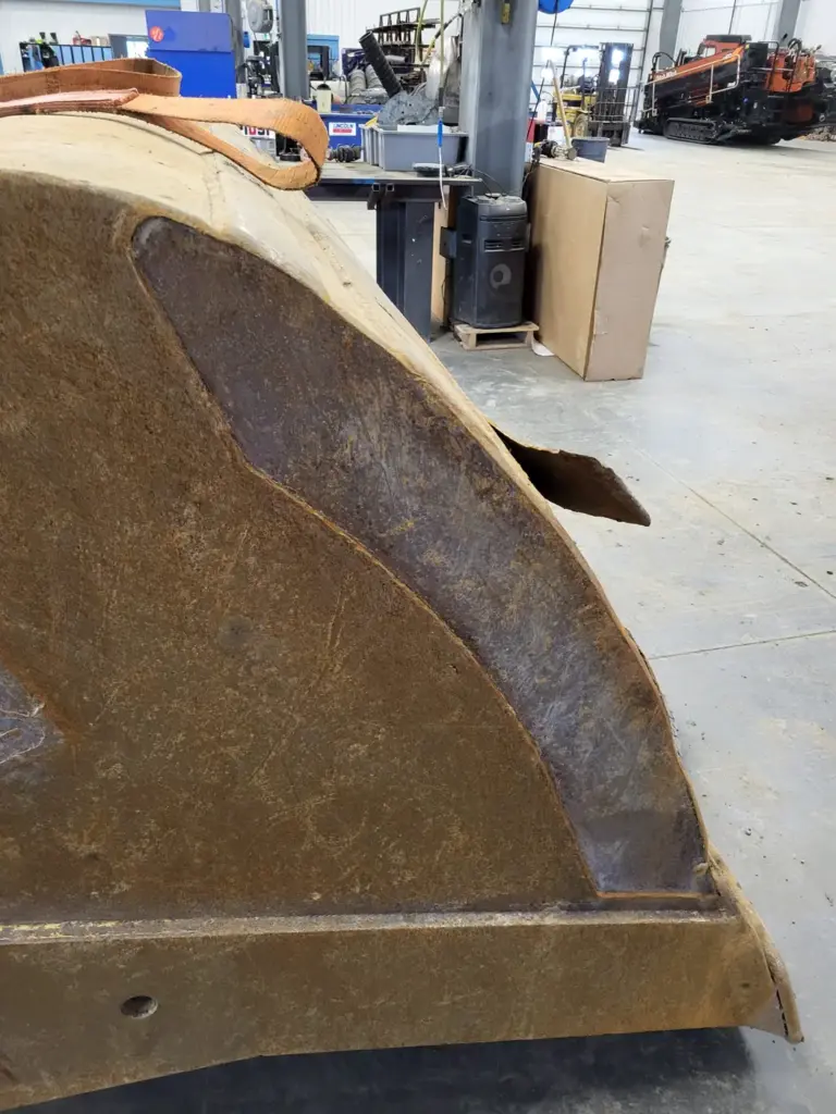 Worn excavator bucket side wall ready for repair