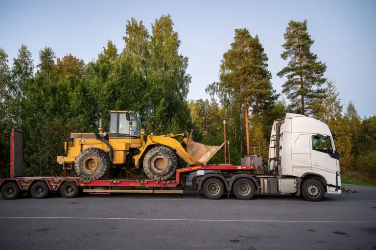 Semi truck hauling a wheel loader on a lowboy trailer