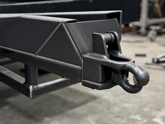 Steel trailer tongue with a pintle eye coupler and welded gusset reinforcement