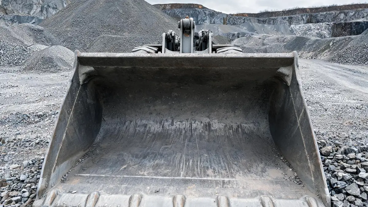 Worn wheel loader bucket with a rounded, thinned cutting edge and worn corners